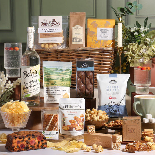 Classic alcohol-free gift basket hamper with sweet and savoury treats displayed, including chocolate, nuts, cake and sparkling elderflower drink.