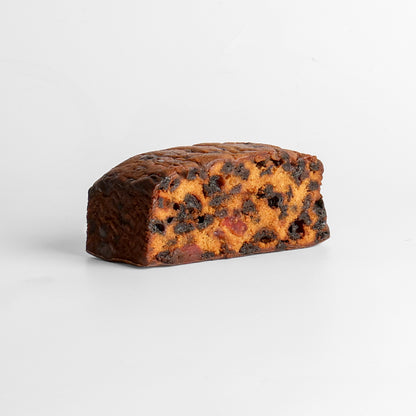 A Christmas fruit cake with fruit pieces, dusted with powdered sugar.
