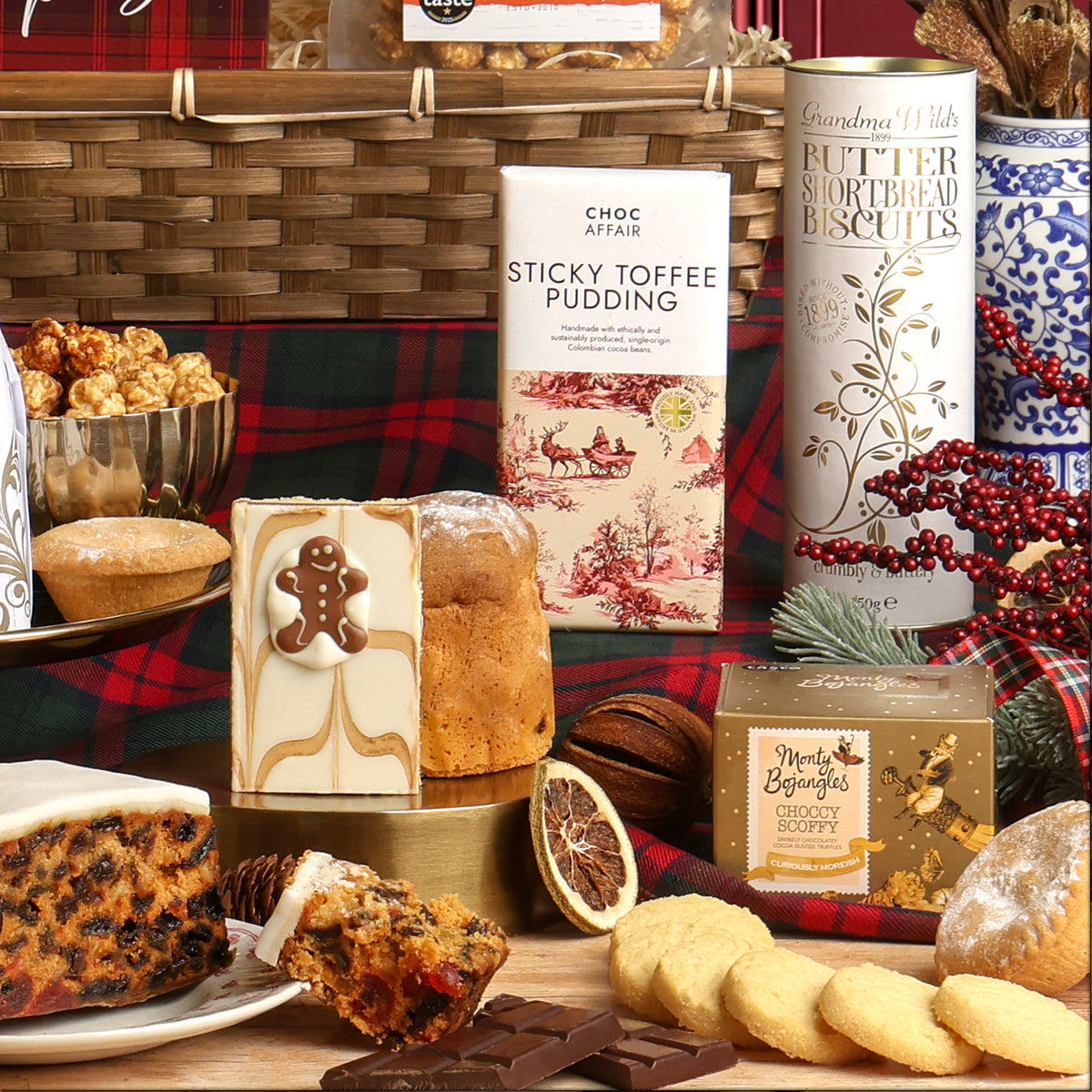 The White Christmas Hamper showing the food items close-up, displayed as a festive spread, with assorted treats and baked goods, including a Christmas fruit cake and biscuits.