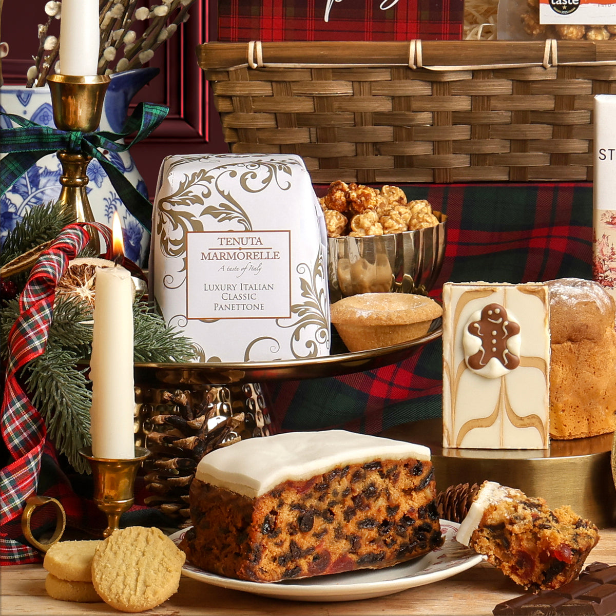The White Christmas Hamper featuring Italian panettone, Christmas cake, and sweet treats, styled as a festive spread with some displayed on a tiered stand.