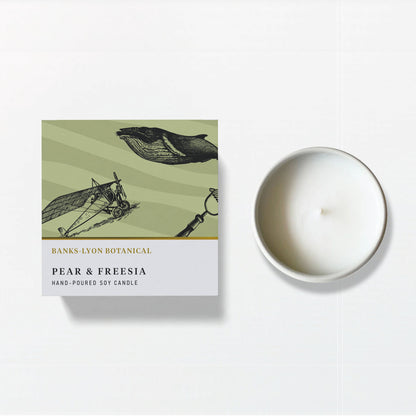 A Banks-Lyon Botanical Pear and Freesia hand-poured soy candle shown with its illustrated box on a white background.