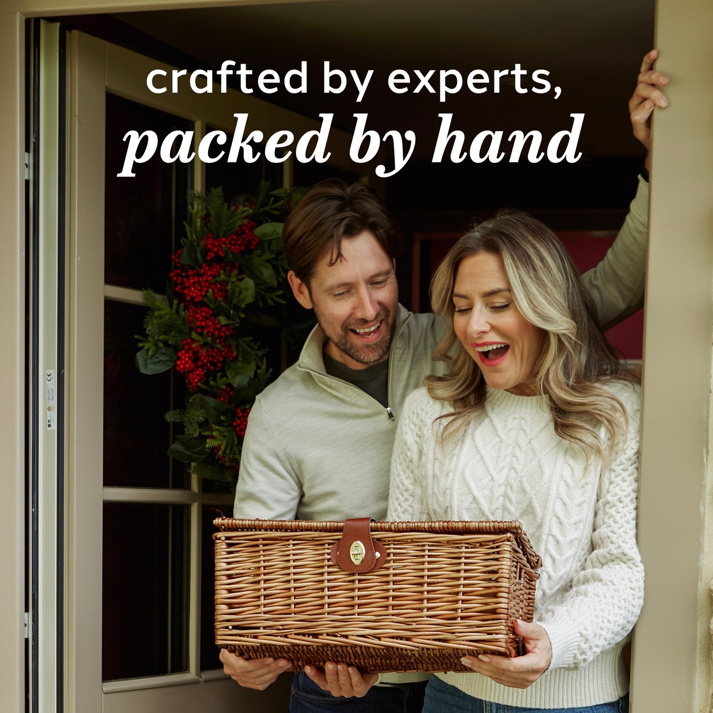 Man and woman holding a wicker basket with text 'crafted by experts, packed by hand' above them.