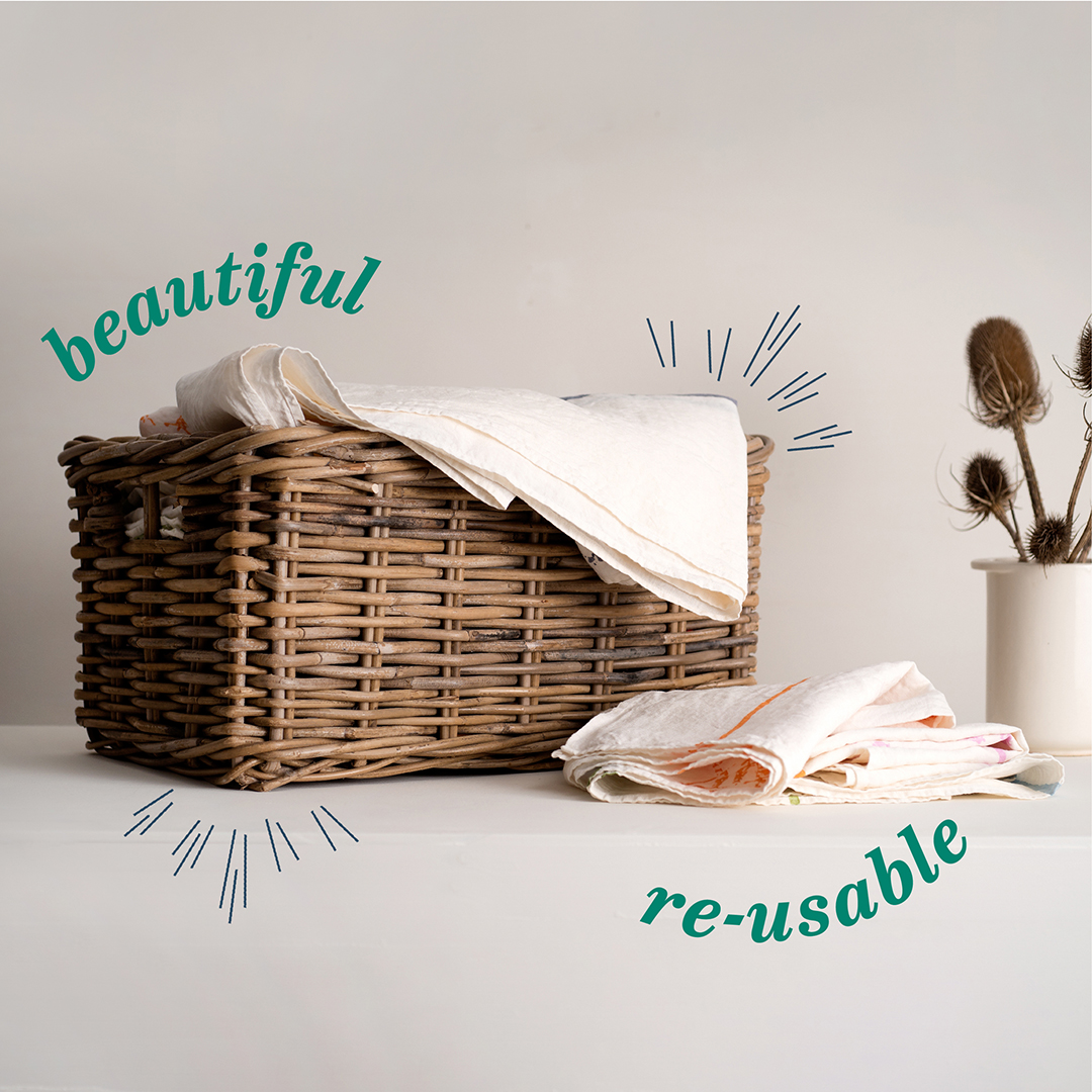 Wicker basket with table linen and words 'beautiful' and 're-usable'
