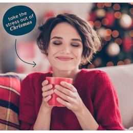 Woman hugging a red mug, smiling, with text that says 'take the stress out of Christmas'