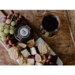 Snowdonia Company cheese truckle, cheese board, crackers, grapes and wine