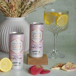 Two tins of gin and tonic, flowers and a glass of G&T of gin and tonic