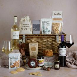 Premium food and wine hamper with contents on display and lidded wicker basket