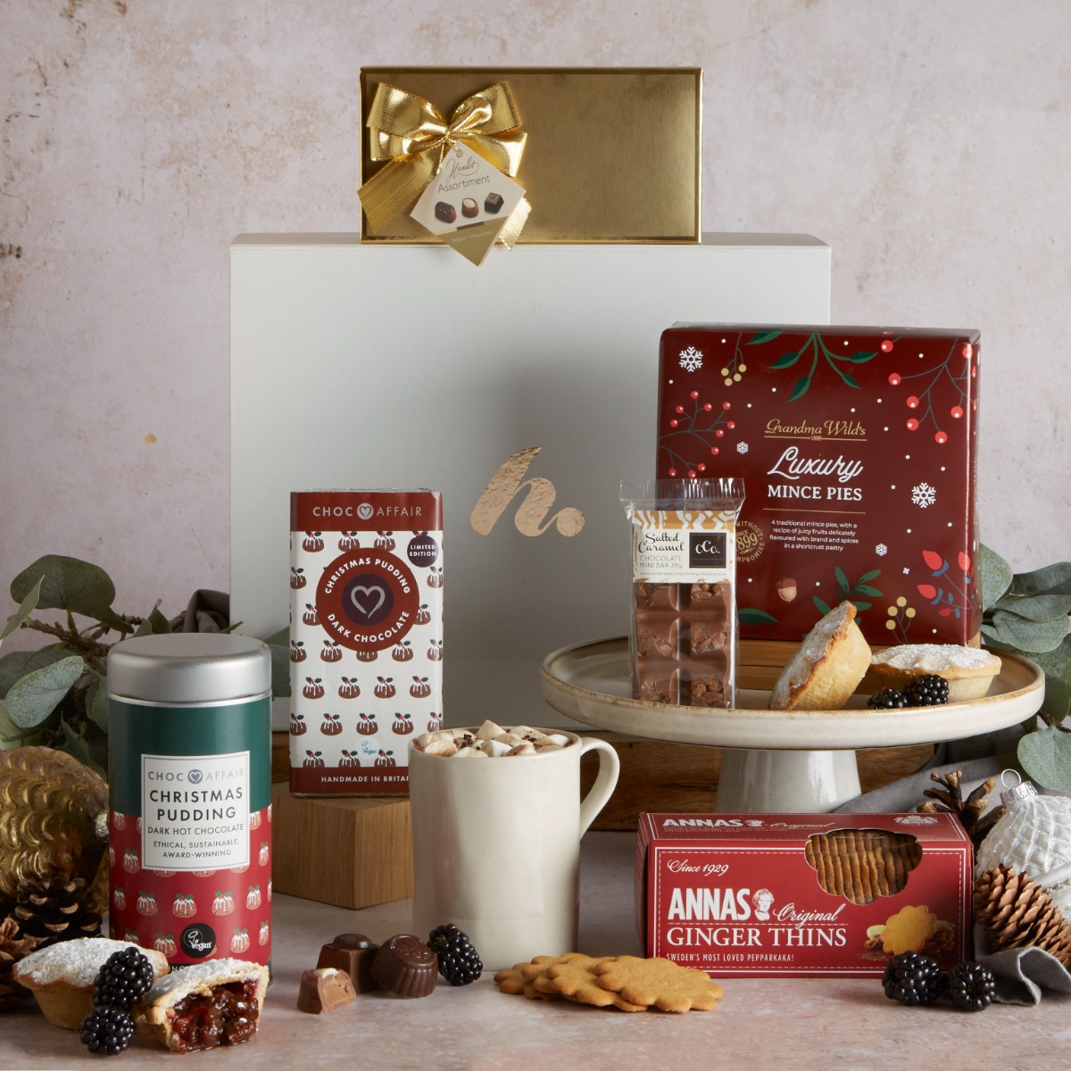 Festive Hot Chocolate Hamper with contents on display and Christmas decoration