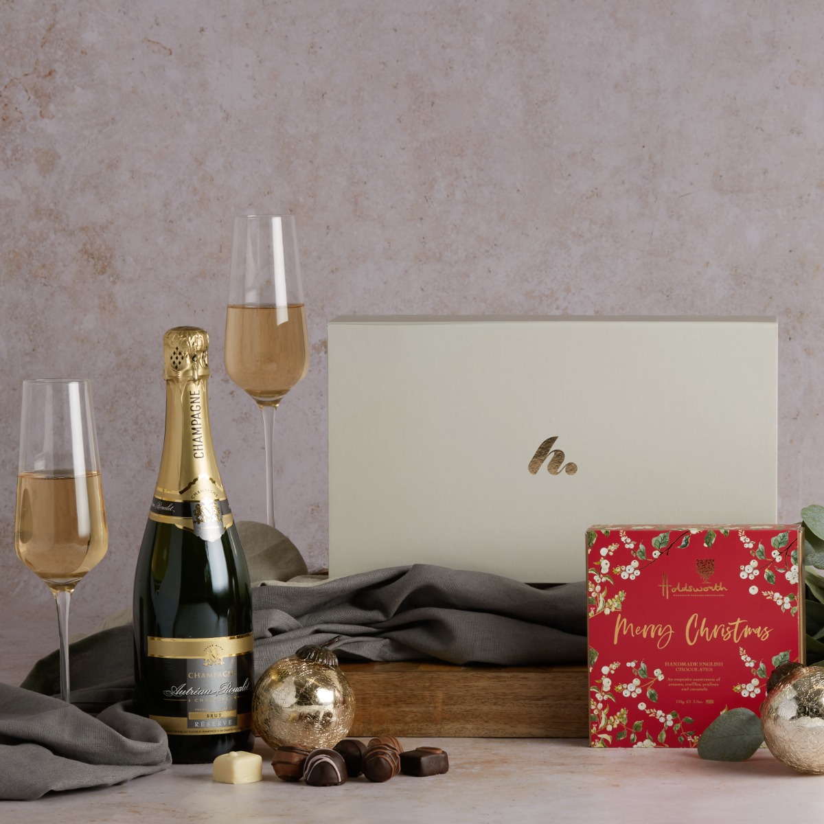  Champagne & Christmas Chocolates with poured flutes of fizz and the contents of this hamper on display