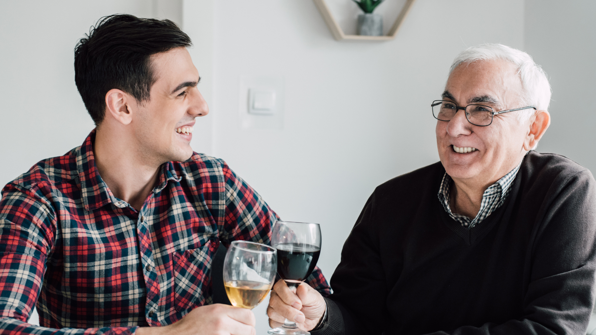 Father and son enjoying a glass of red and white wine