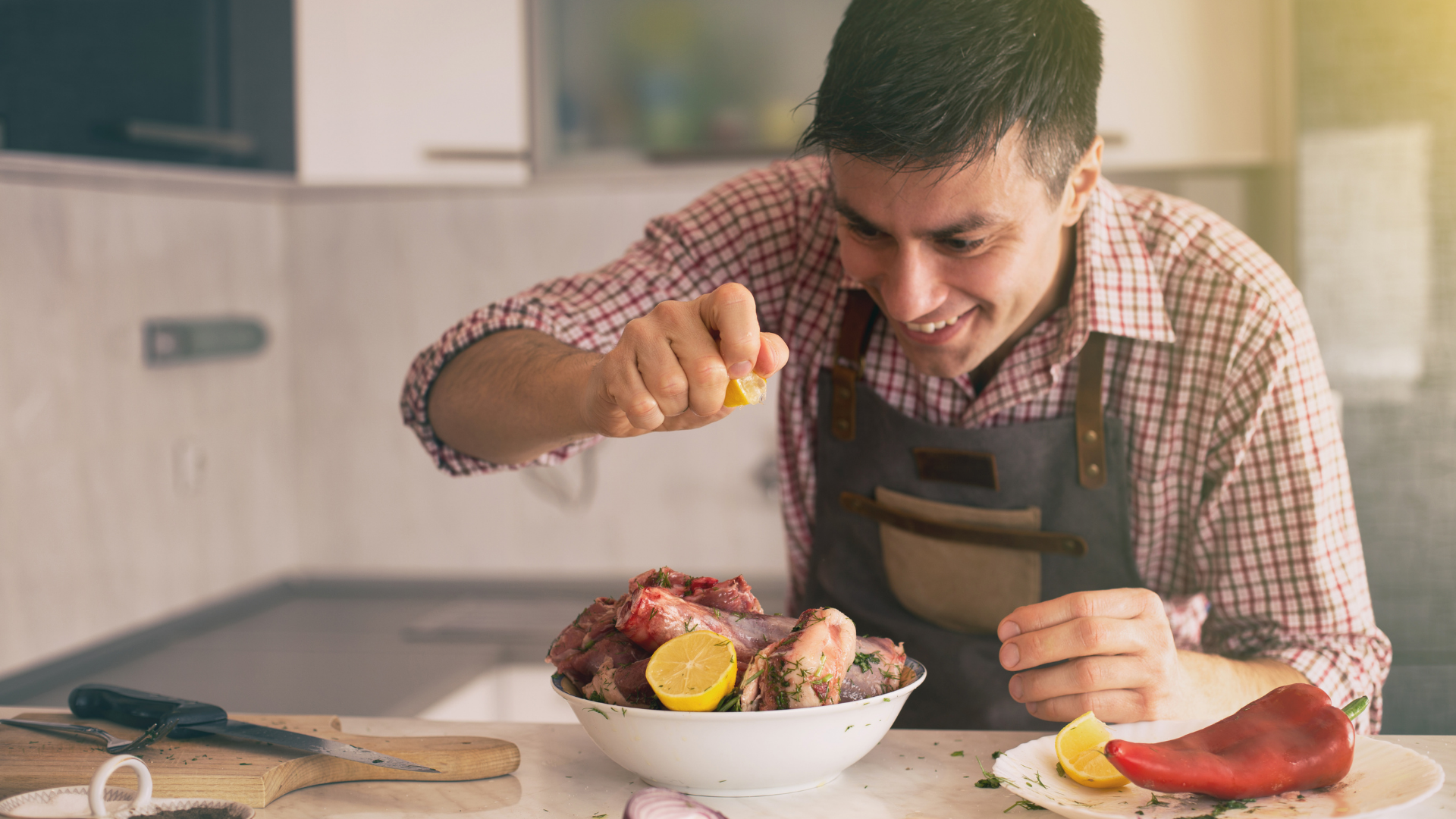 Man in apron squeezing lemon juice over meal he has made
