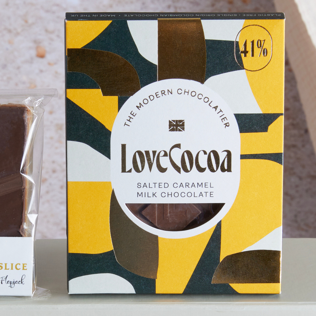 Broken up bar of Love Cocoa with caramel swirls on a yellow background