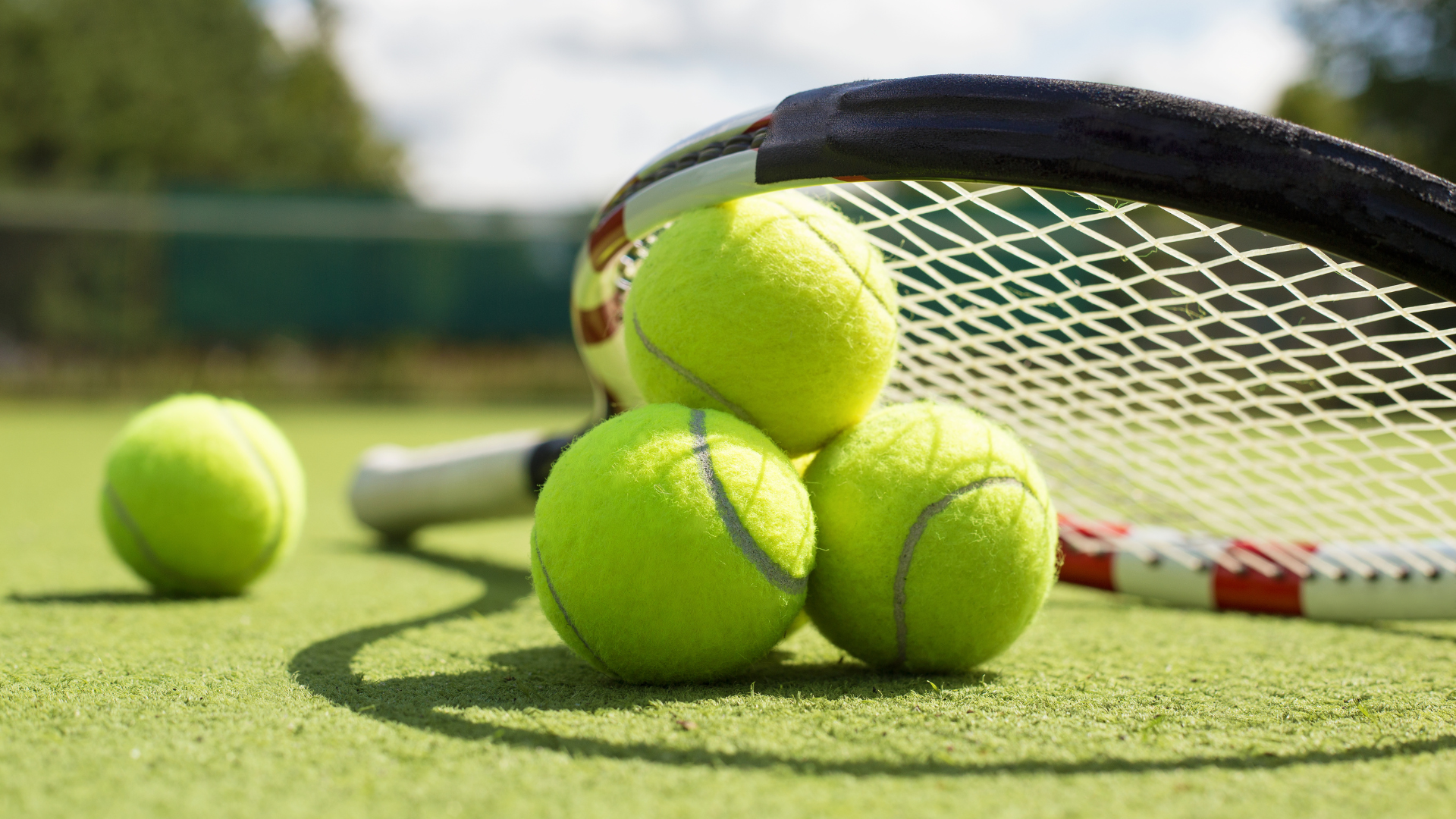 Tennis racket and balls on grass court