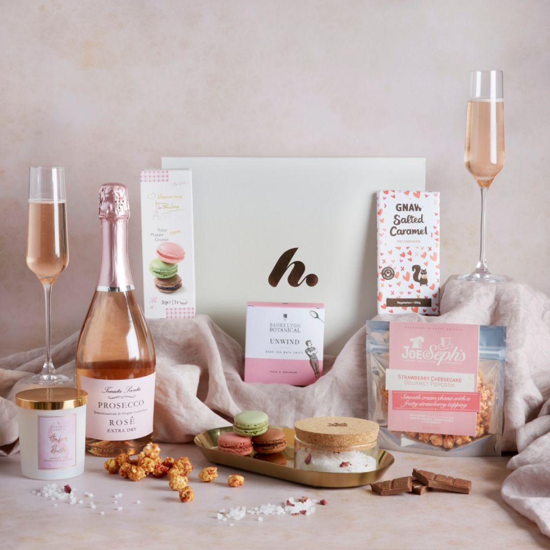 Pamper Hamper contents on display with a glass of prosecco