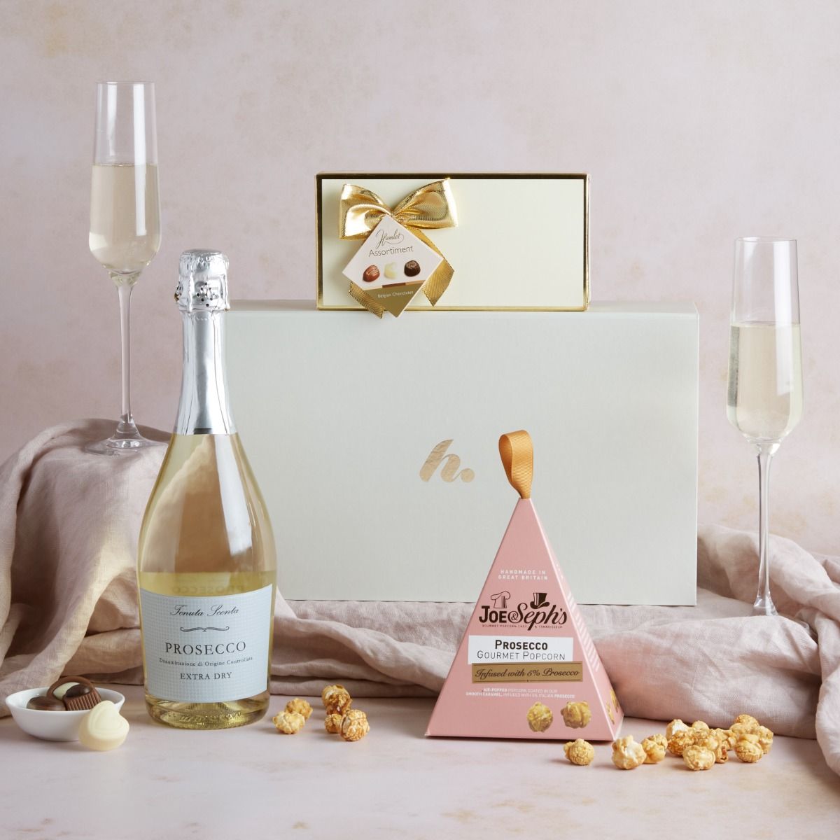 The prosecco & treats hamper with contents on display and the signature cream gift box