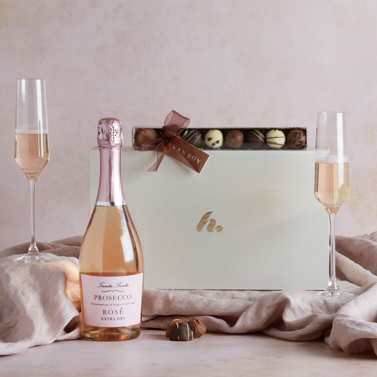 Prosecco Rosé and Truffles Hamper with contents on display and Prosecco in a flute