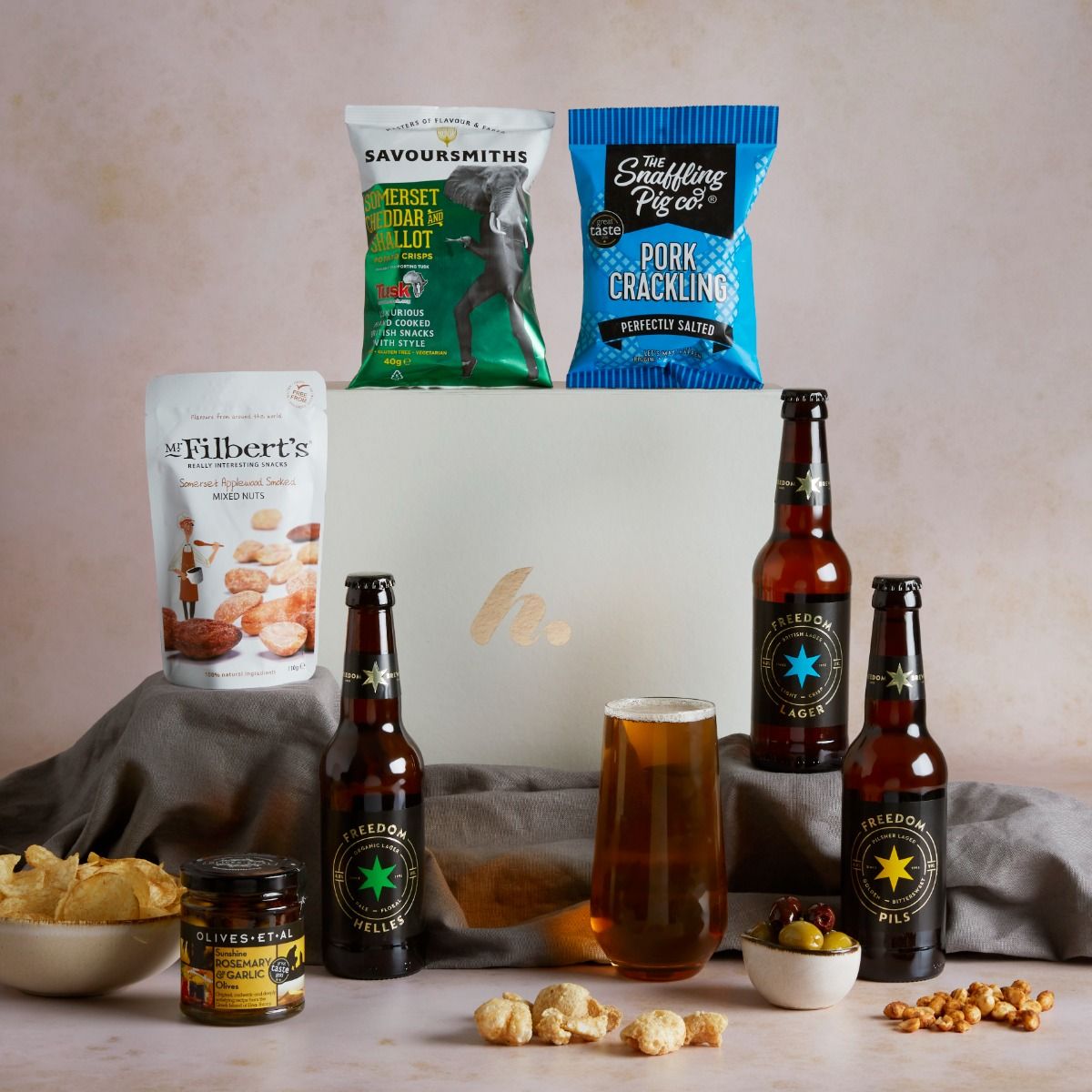 The Craft Beer Hamper with contents on display, a glass of beer and a signature gift box