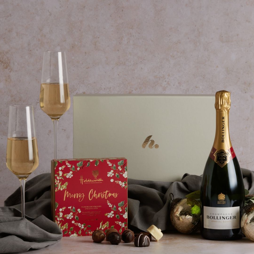 Luxury Champagne and Christmas chocolates hamper displayed with two champagne flutes and a signature gift box