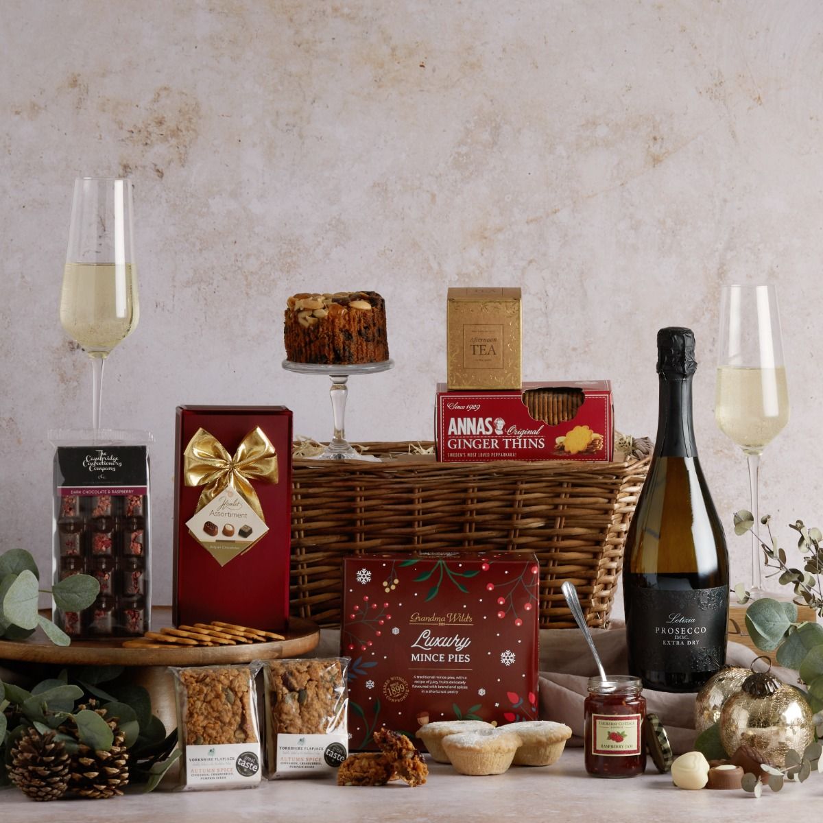 Festive afternoon tea hamper with all its contents on display and a wicker basket