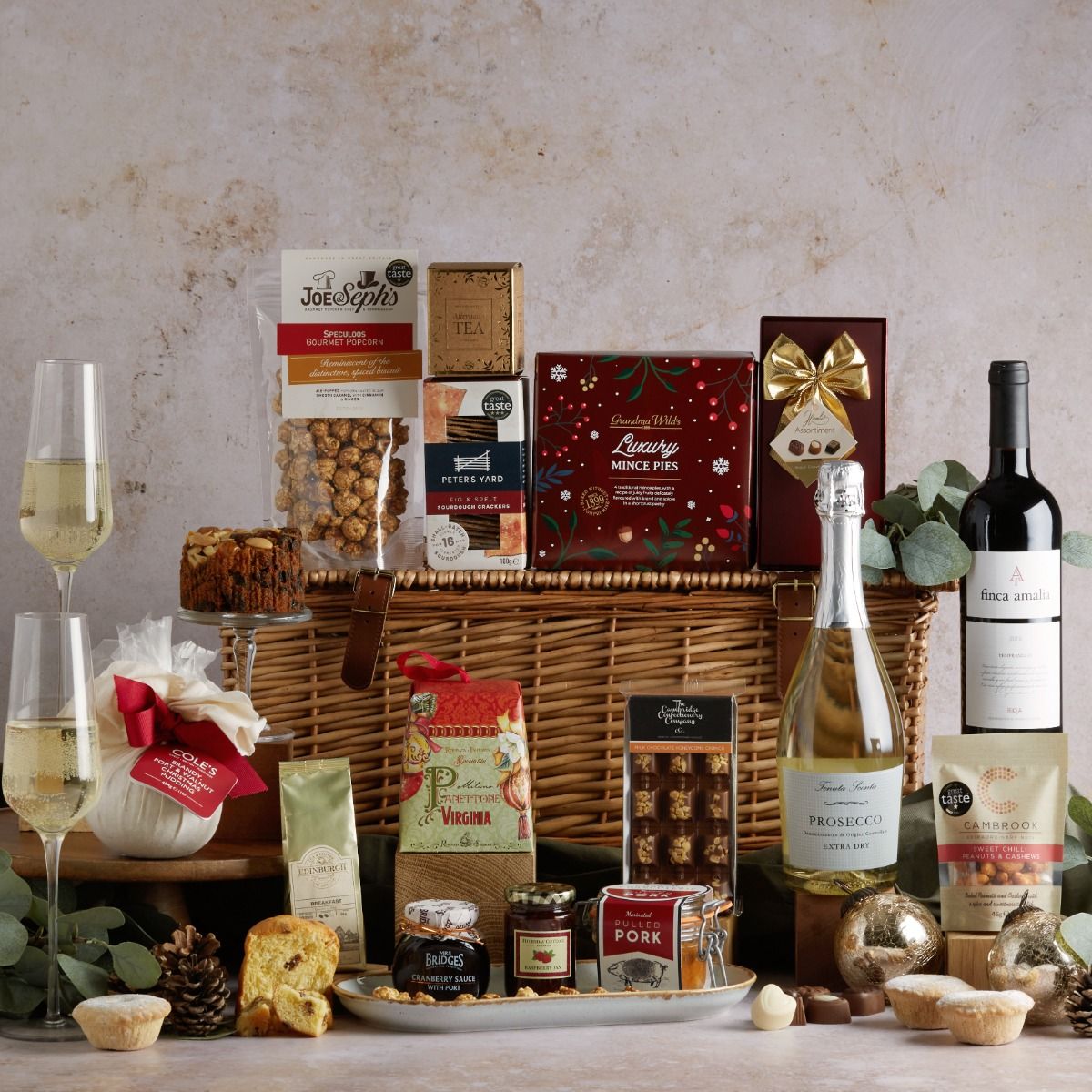 The Traditional Christmas Hamper with all of its contents on display and a wicker basket