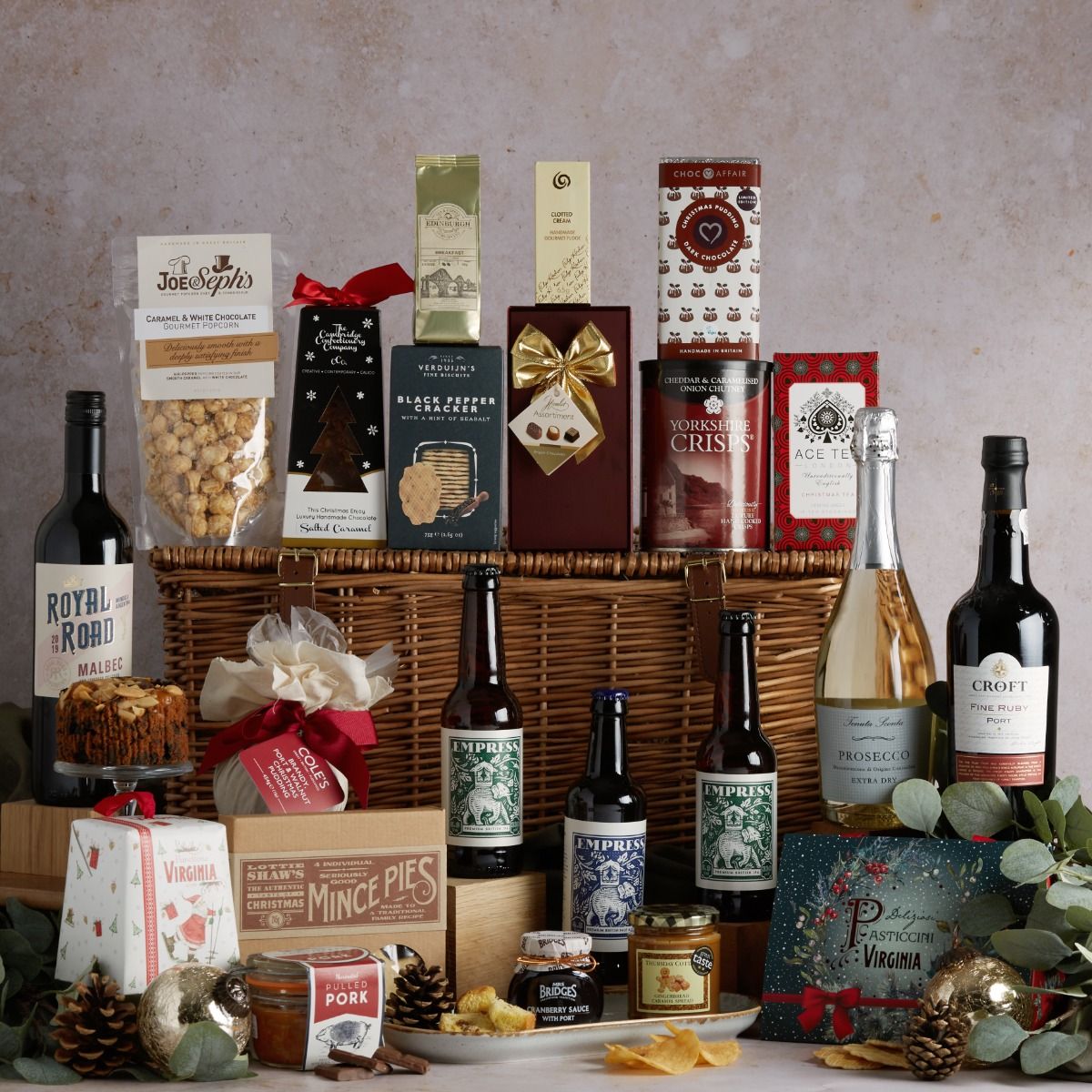 The Luxury Family Christmas Hamper with its contents on display and a wicker basket
