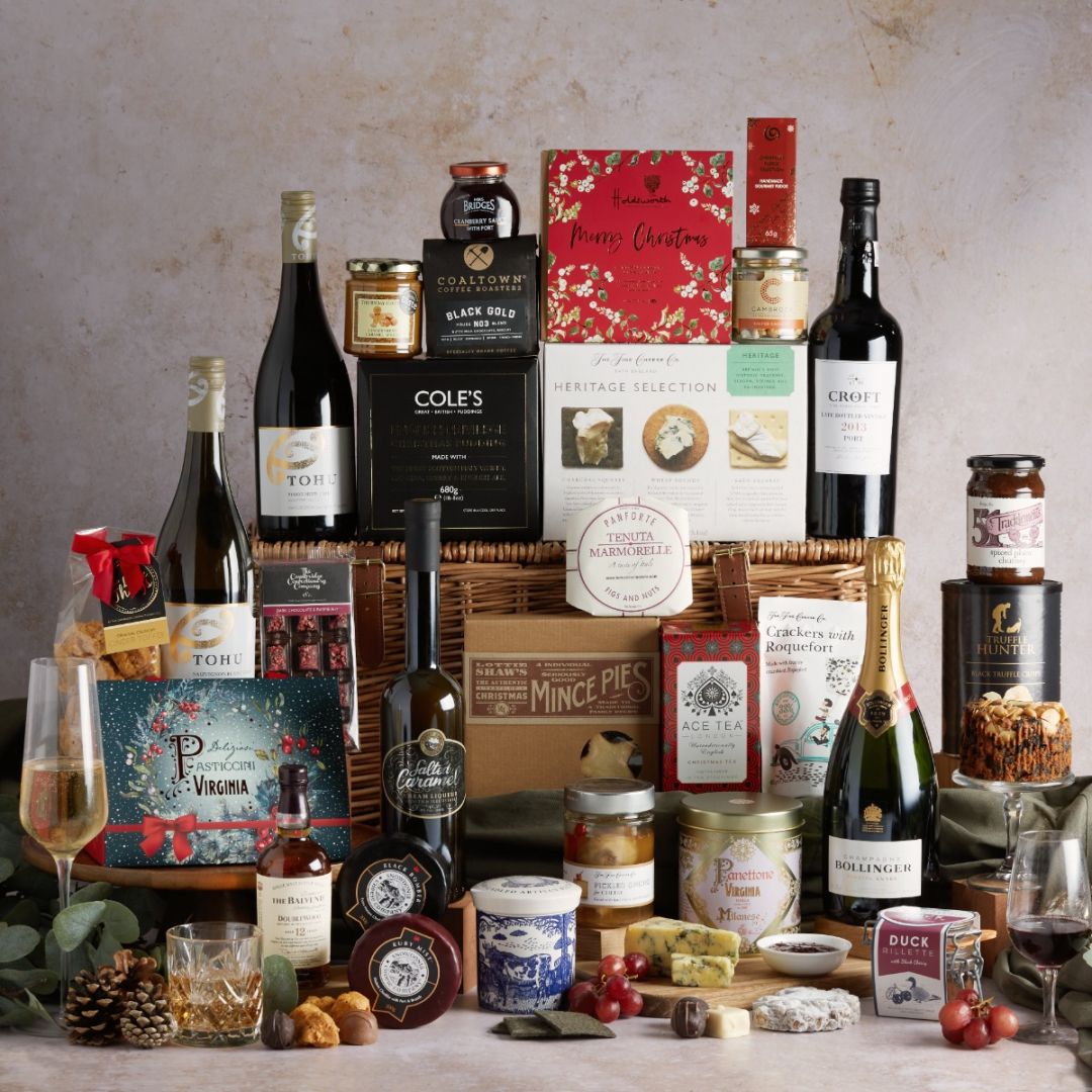 The Magnificent Christmas Hamper with all of its food and drink products on display, with a wicker lidded basket