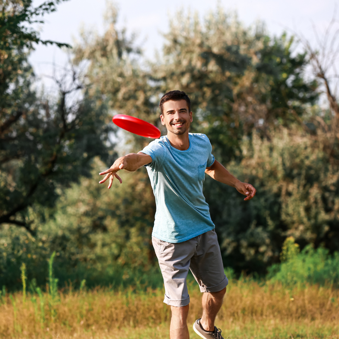 Young man or dad throwing frisbee towards the camera 