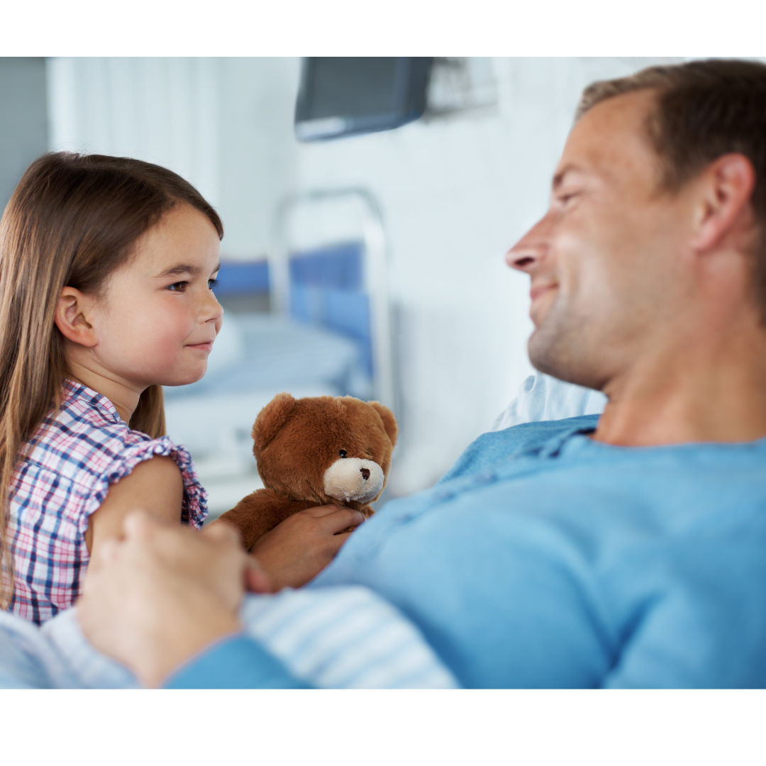 Little girl with teddy smiling at man in a hospital bed