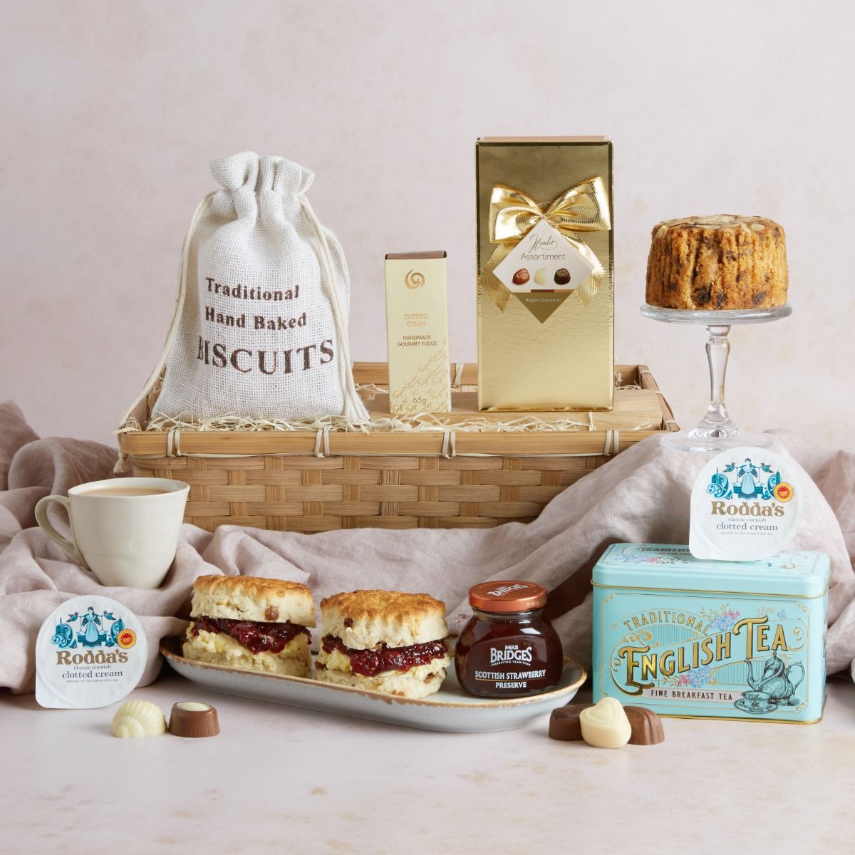 Luxury Cream Tea Gift Hamper with contents on display including scones topped with jam and clotted cream