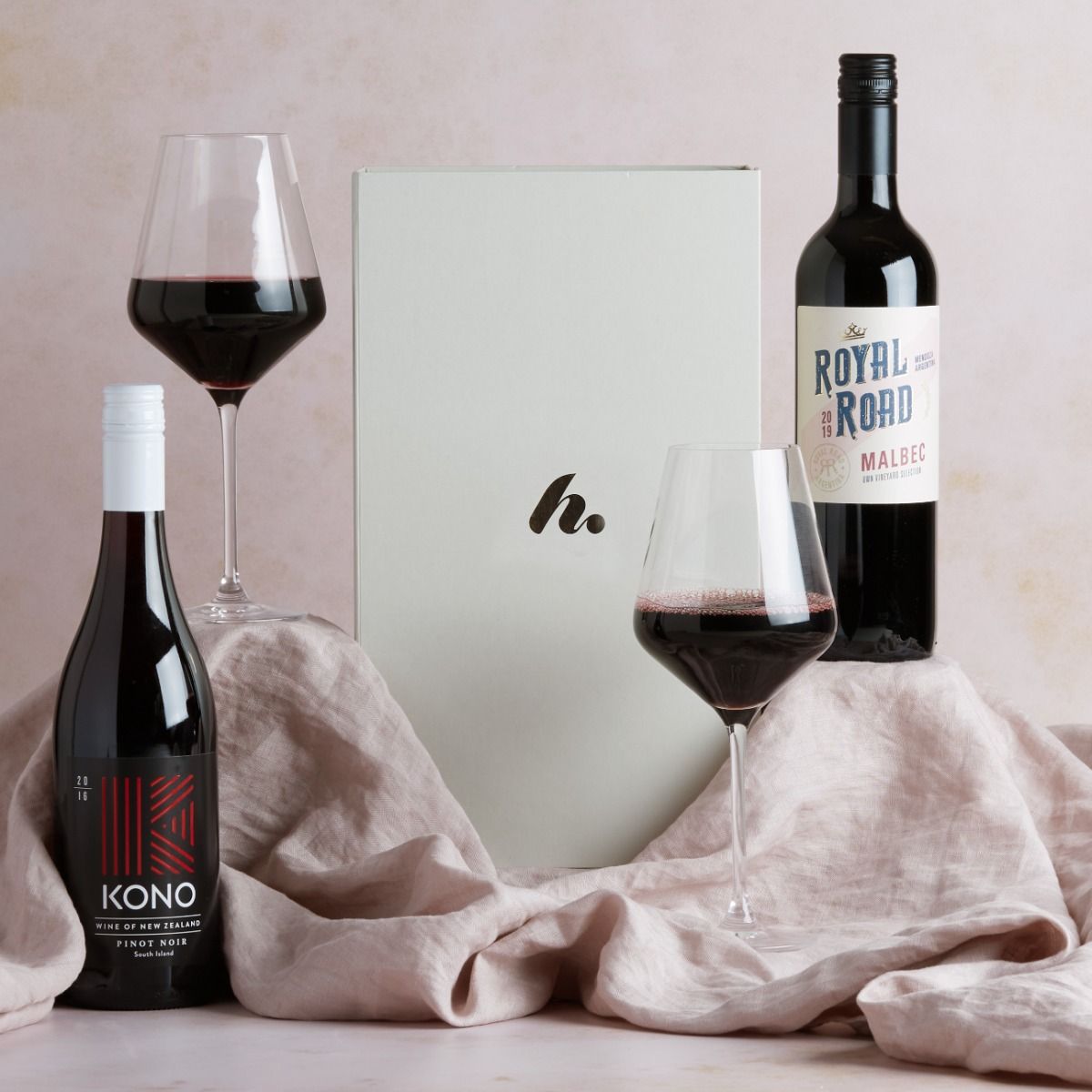 The Red Wine Duo Gift Box with wine and glasses of wine on display with signature gift box